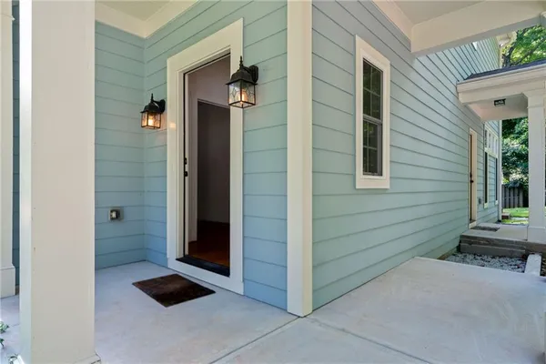 a view of a hallway with wooden floor and windows