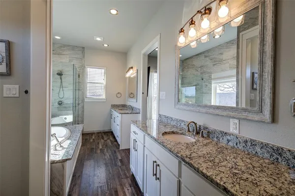 a bathroom with a granite countertop sink mirror and a toilet