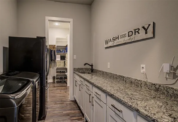 a kitchen with granite countertop kitchen island stainless steel appliances a sink stove top oven and refrigerator