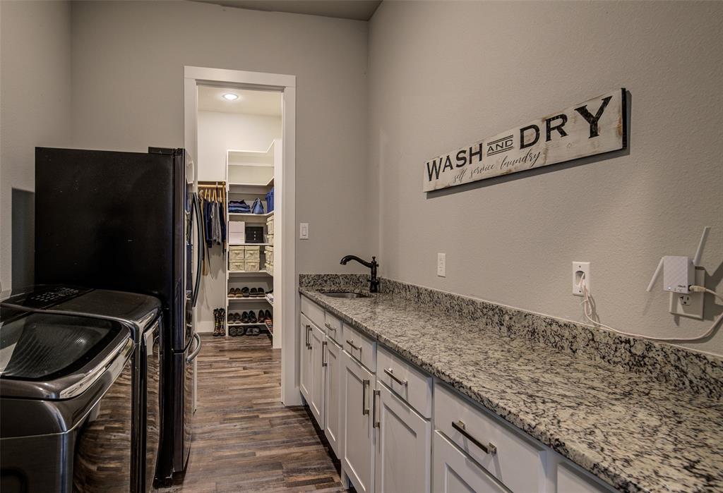 133 Sunset Bay Pointe Court Chico, TX 76431 - Photo 20 of 40 Kitchen with light stone counters, white cabinetry, independent washer and dryer, and a sink