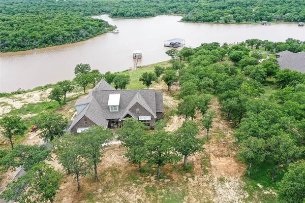 an aerial view of a house with a yard and lake view