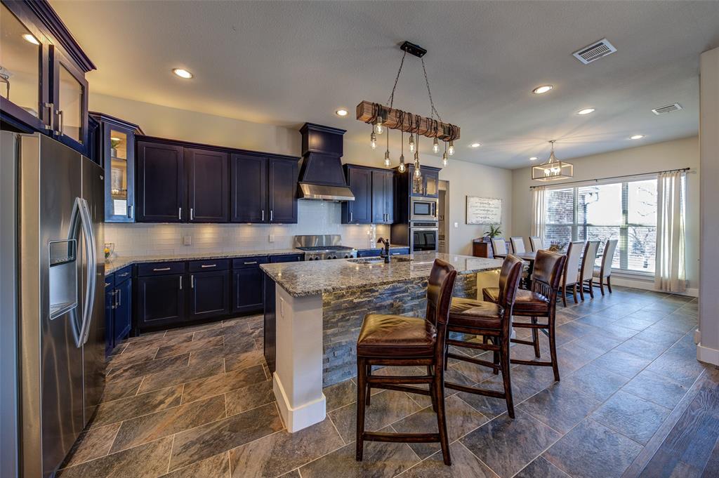 133 Sunset Bay Pointe Court Chico, TX 76431 - Photo 5 of 40 Kitchen featuring a kitchen island with sink, premium range hood, hanging light fixtures, appliances with stainless steel finishes, and glass insert cabinets