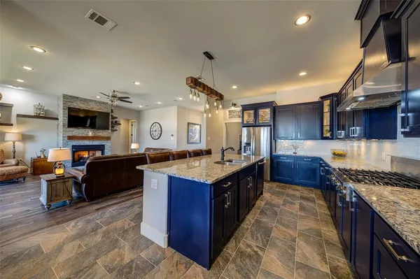 a open kitchen with stainless steel appliances granite countertop a stove oven and a refrigerator