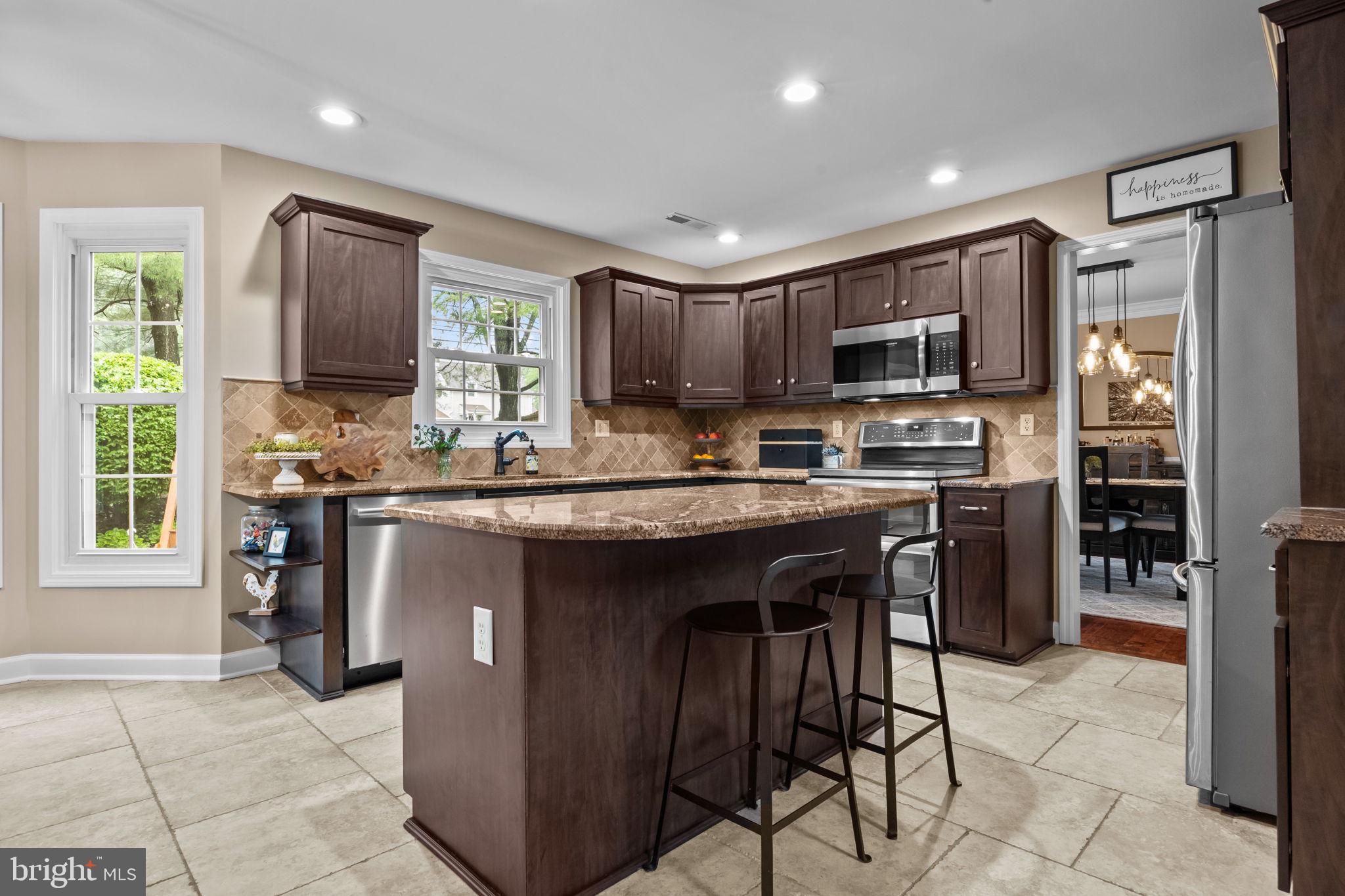 121 Beech Drive Hatboro, PA 19040 - Photo 12 of 46 a kitchen with kitchen island granite countertop wooden cabinets a refrigerator a stove a sink and a oven