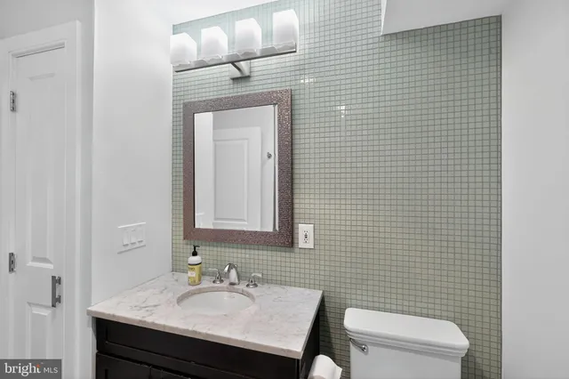 a bathroom with a sink a toilet and mirror