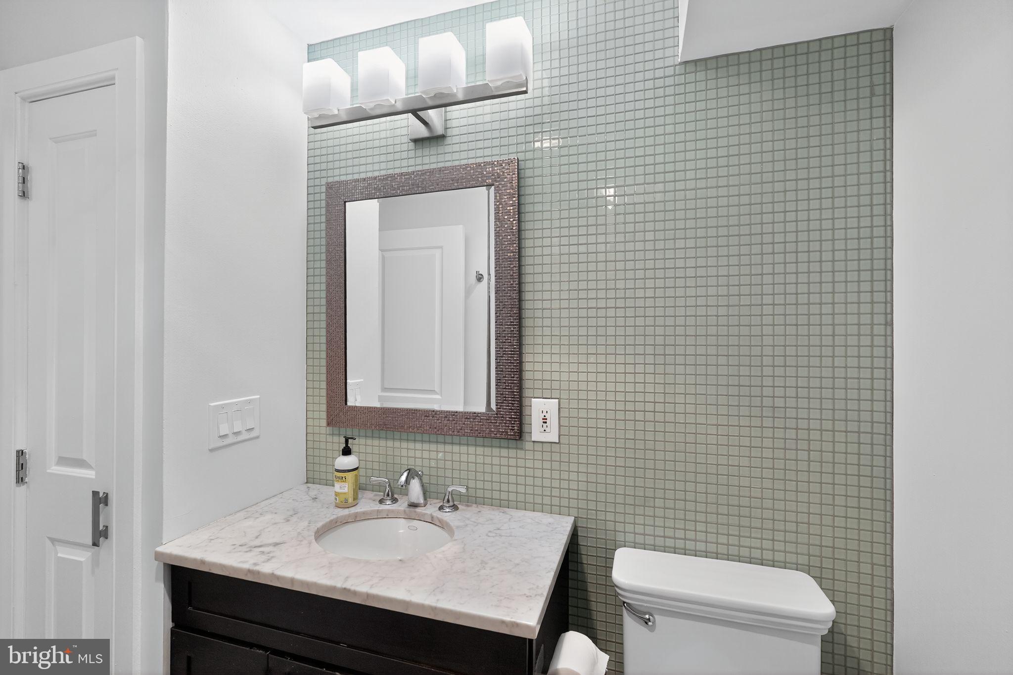 1522 Race Street, Unit 3 Philadelphia, PA 19102 - Photo 11 of 17 a bathroom with a sink a toilet and mirror