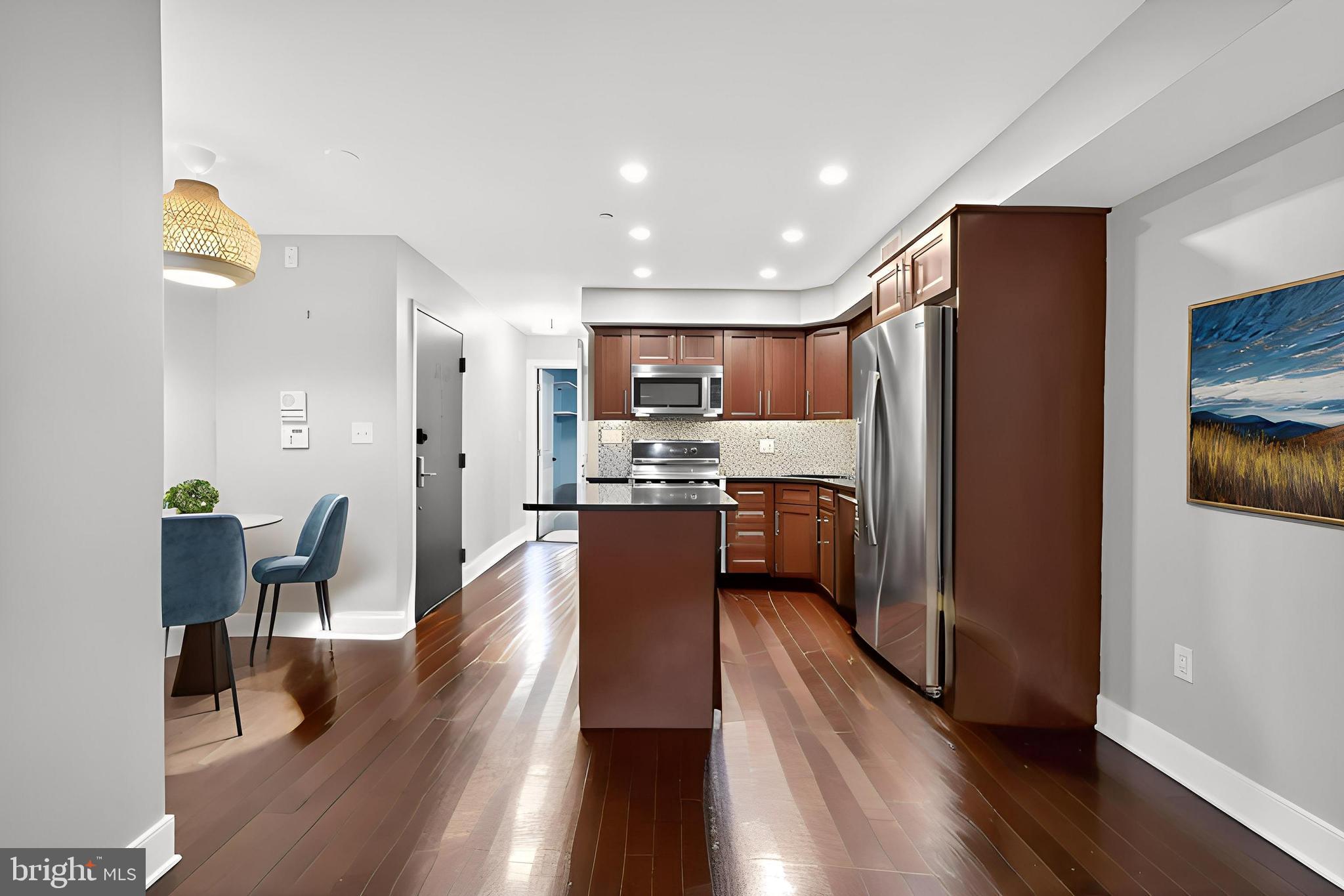 1522 Race Street, Unit 3 Philadelphia, PA 19102 - Photo 5 of 17 a kitchen with stainless steel appliances granite countertop wooden floors a refrigerator and a stove