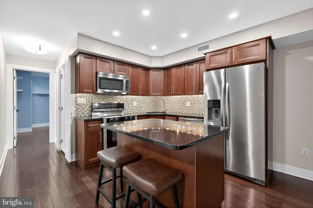 a kitchen with granite countertop stainless steel appliances and wooden cabinets