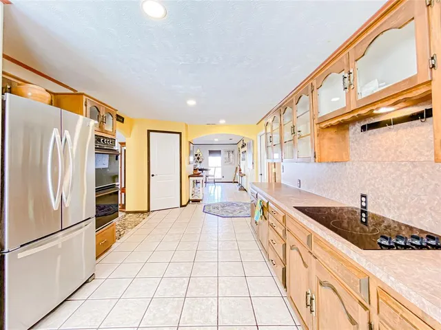 a large white kitchen with a sink and refrigerator