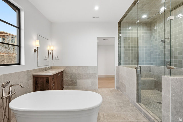 2155 East Wrangler Road Kamas, UT 84036 - Photo 47 of 62 Bathroom featuring tile walls, a freestanding bath, vanity, a wainscoted wall, and a shower stall