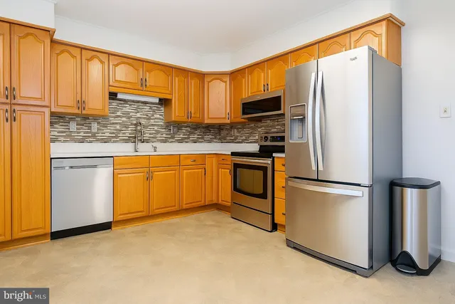 a kitchen with stainless steel appliances granite countertop a refrigerator sink and cabinets
