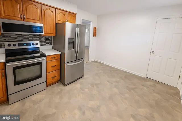 a kitchen with stainless steel appliances granite countertop a refrigerator stove and microwave
