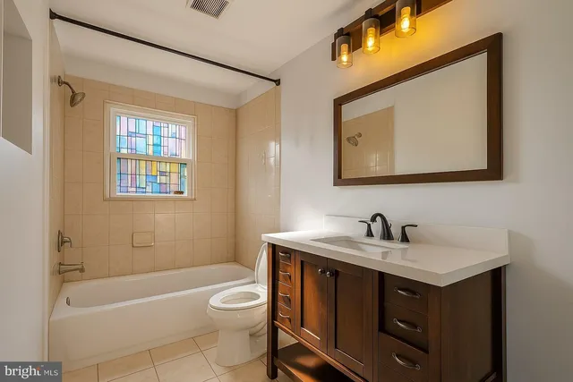 a bathroom with a toilet a sink a mirror and a bathtub