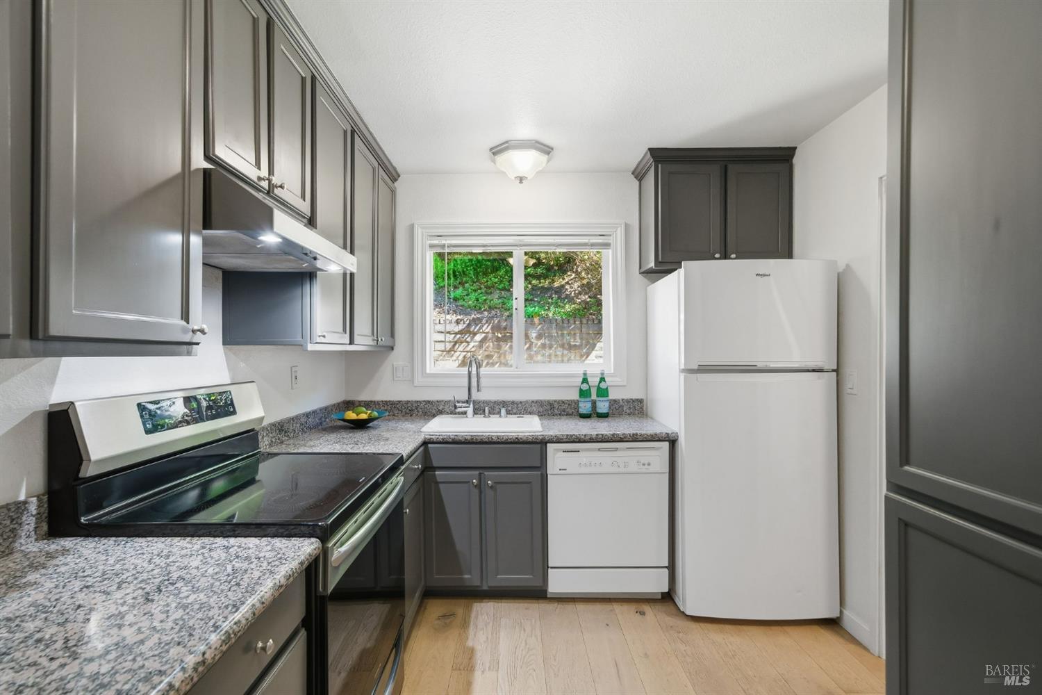 10 Professional Center Parkway, Unit 1 San Rafael, CA 94903 - Photo 11 of 35 a kitchen with stainless steel appliances granite countertop a refrigerator a sink dishwasher a stove with white cabinets and wooden floor