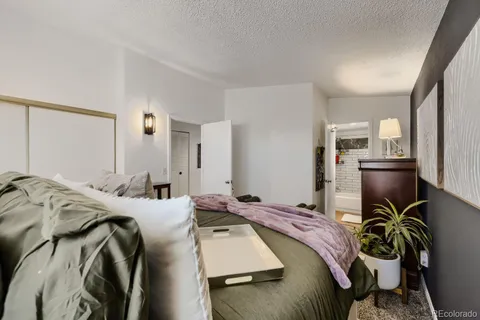 a bed sitting in a bedroom next to a window and tv