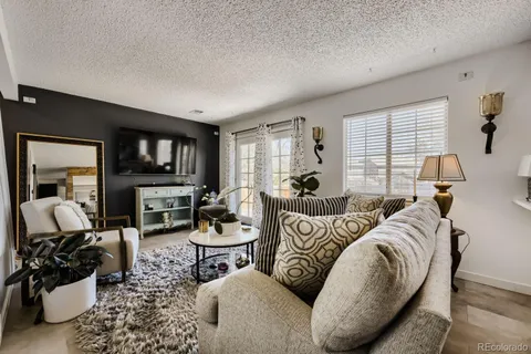 a living room with furniture a large window and a flat screen tv