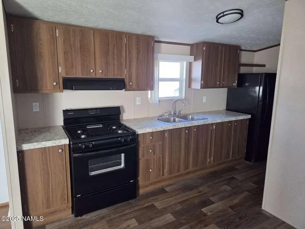 a kitchen with a stove a sink and a refrigerator