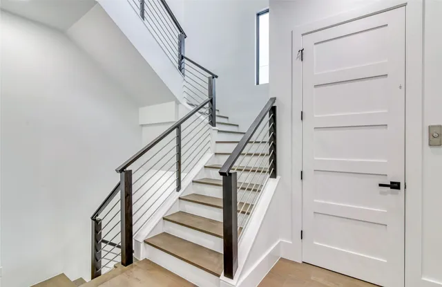 a bedroom with a bed chandelier and a window