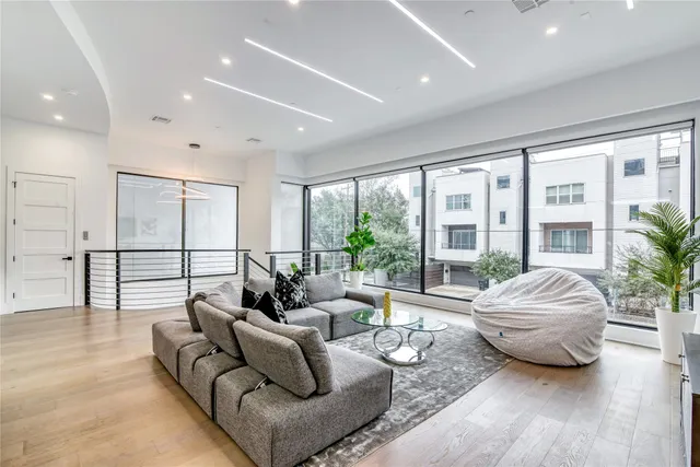 a kitchen with stainless steel appliances kitchen island a table chairs and a refrigerator