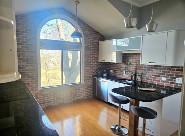 a kitchen with granite countertop a stove a sink and a window
