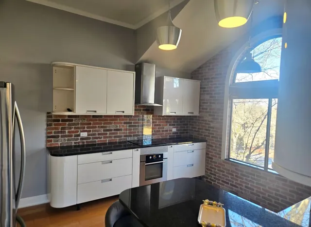 a kitchen with kitchen island granite countertop a stove a sink and a refrigerator