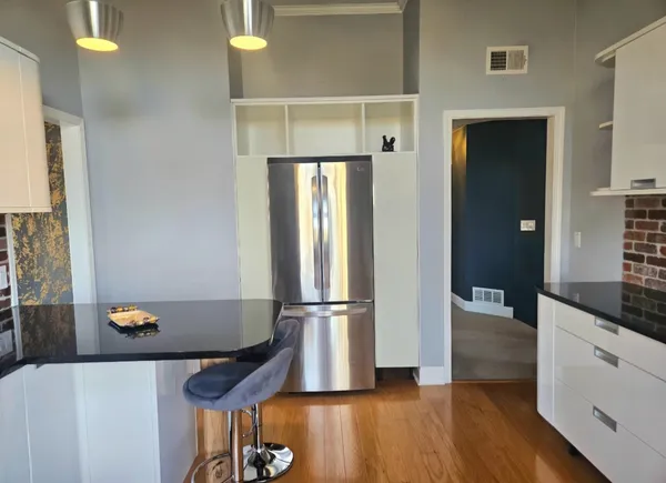 a kitchen with a refrigerator and wooden floor