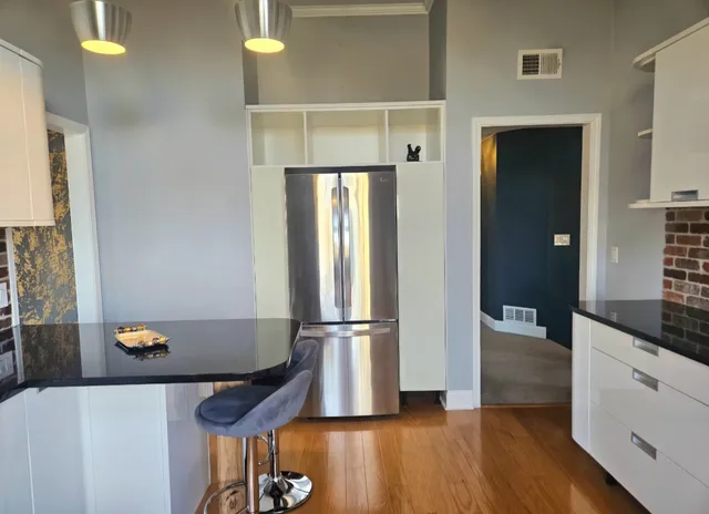a kitchen with a refrigerator and wooden floor