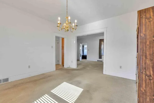 a view of an empty room with a chandelier