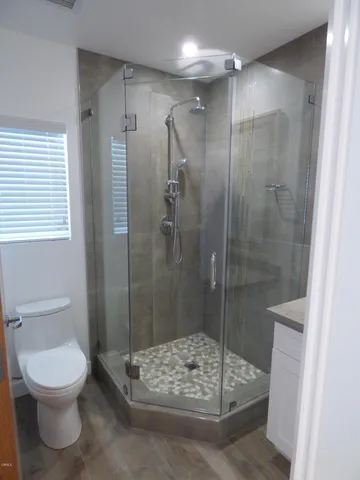 a bathroom with a shower a toilet and a sink