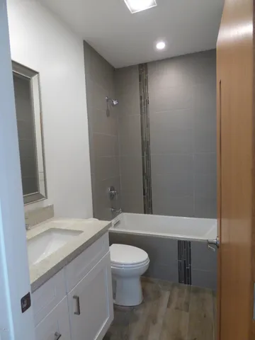 a bathroom with a toilet a sink and mirror