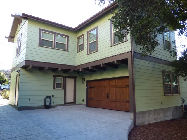 a view of a house with a garage and balcony