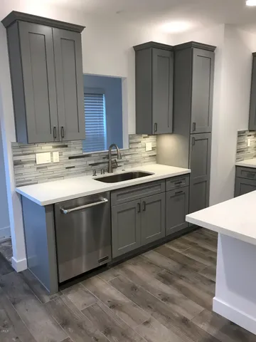 a kitchen with a sink cabinets and wooden floor