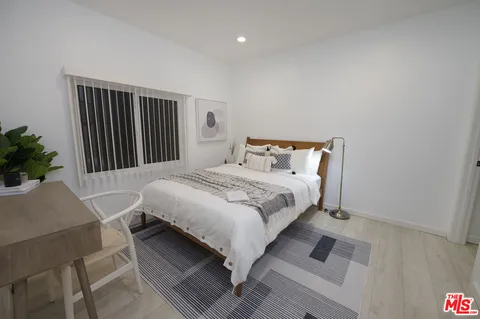 a bedroom with a bed and a potted plant