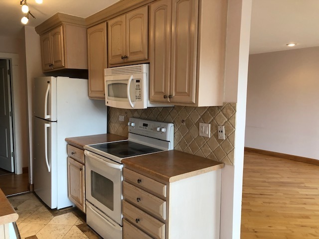 725 West Huntington Commons Road, Unit 401 Mount Prospect, IL 60056 - Photo 2 of 13 a kitchen with stainless steel appliances granite countertop a stove a refrigerator and a microwave