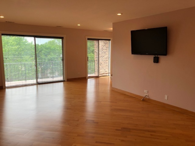 725 West Huntington Commons Road, Unit 401 Mount Prospect, IL 60056 - Photo 7 of 13 a view of a livingroom with wooden floor and a flat screen tv