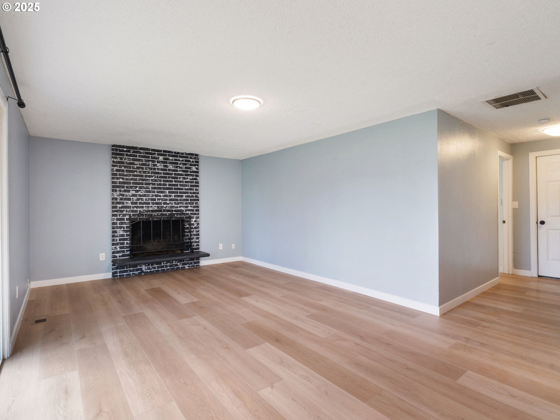 824 Southeast 207th Avenue Gresham, OR 97030 - Photo 21 of 47 a view of an empty room with wooden floor and a fireplace
