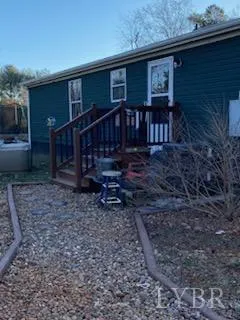 a view of a house with wooden deck front of house