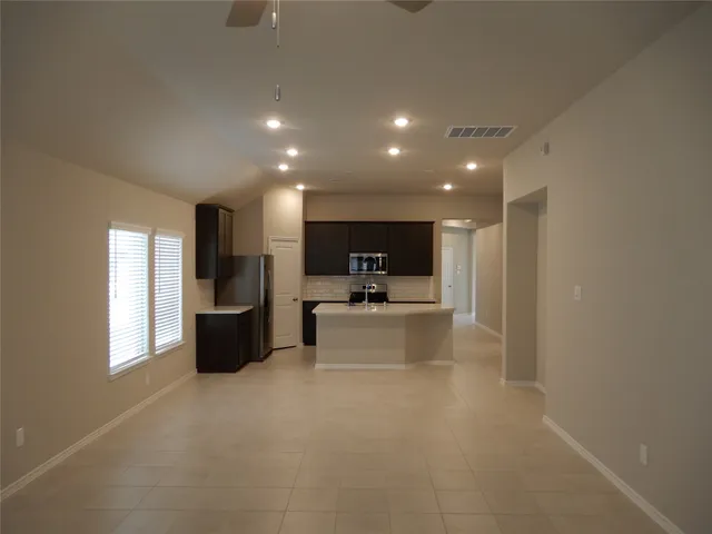 a kitchen with a sink a microwave a refrigerator and cabinets