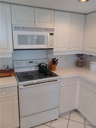 a kitchen with white cabinets and white appliances