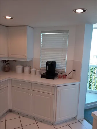 a kitchen with white cabinets and sink