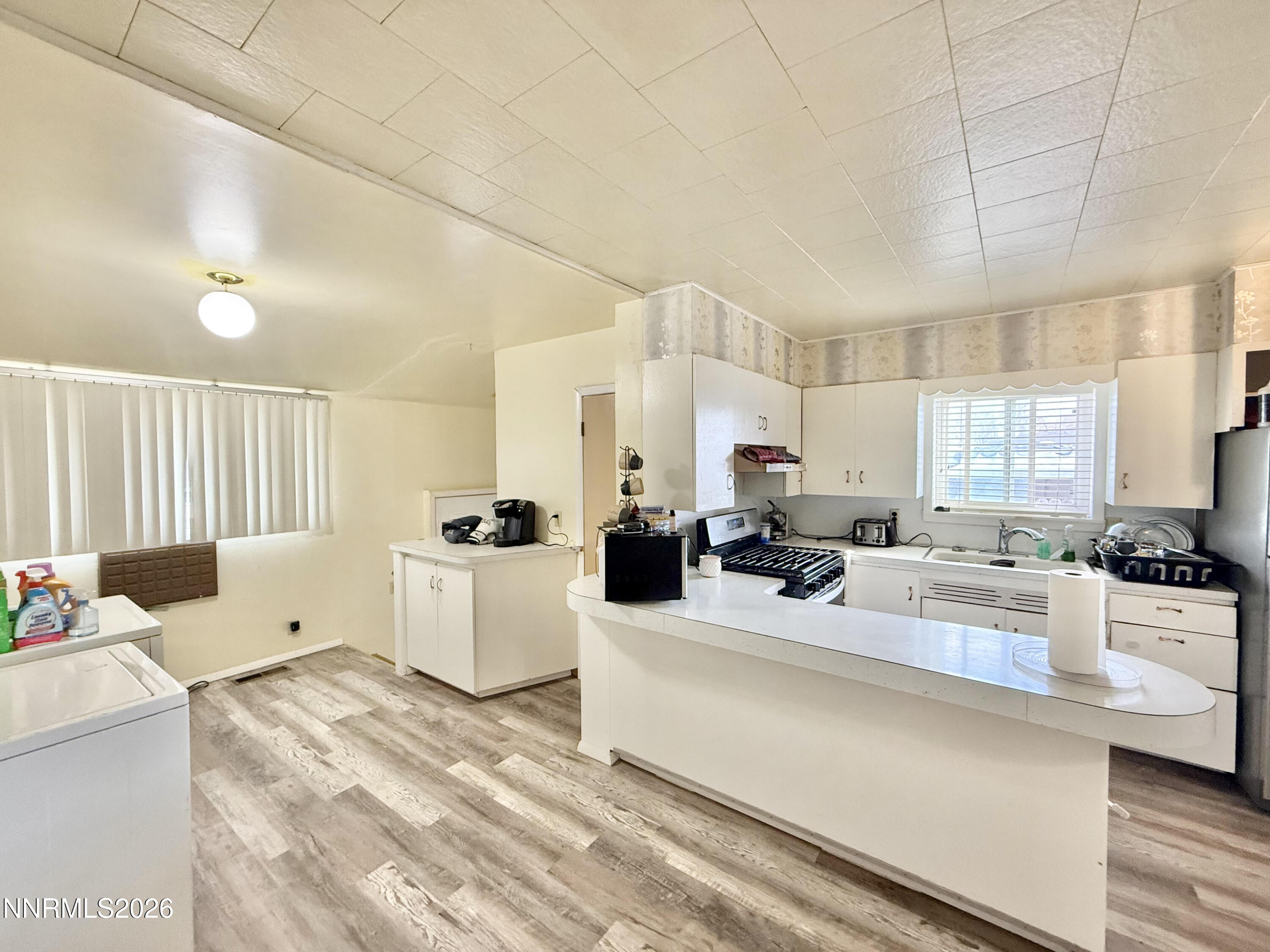 68 West 5th Street Battle Mountain, NV 89820 - Photo 12 of 20 a kitchen with sink stove and white cabinets with wooden floor