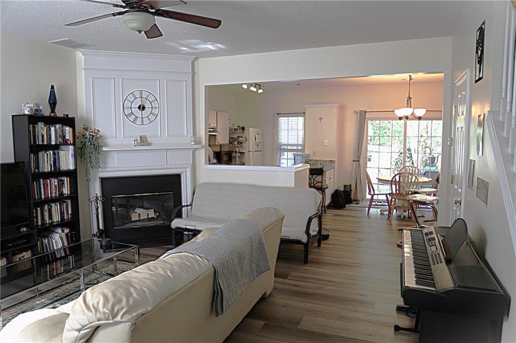3767 Berkeley Crossing Duluth, GA 30096 - Photo 4 of 23 a living room with furniture a fireplace and a chandelier