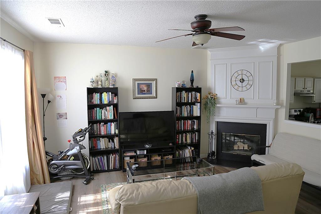 3767 Berkeley Crossing Duluth, GA 30096 - Photo 6 of 23 a living room with furniture a fireplace and a flat screen tv