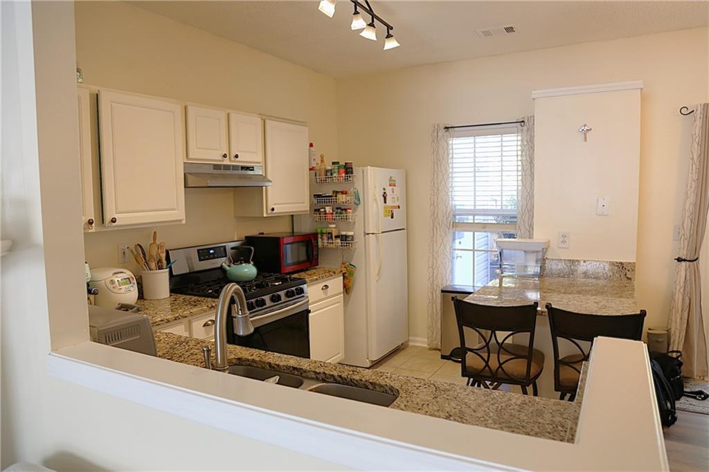3767 Berkeley Crossing Duluth, GA 30096 - Photo 7 of 23 a kitchen with a table chairs and a refrigerator