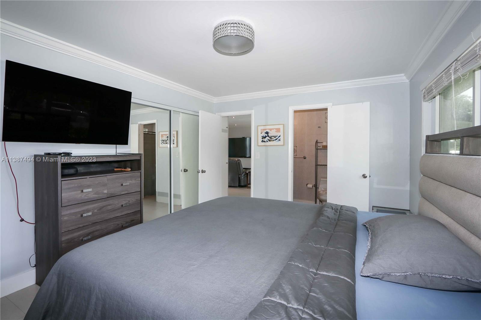 9275 Southwest 45th Street Miami, FL 33165 - Photo 12 of 23 a large bedroom with a bed and a flat screen tv