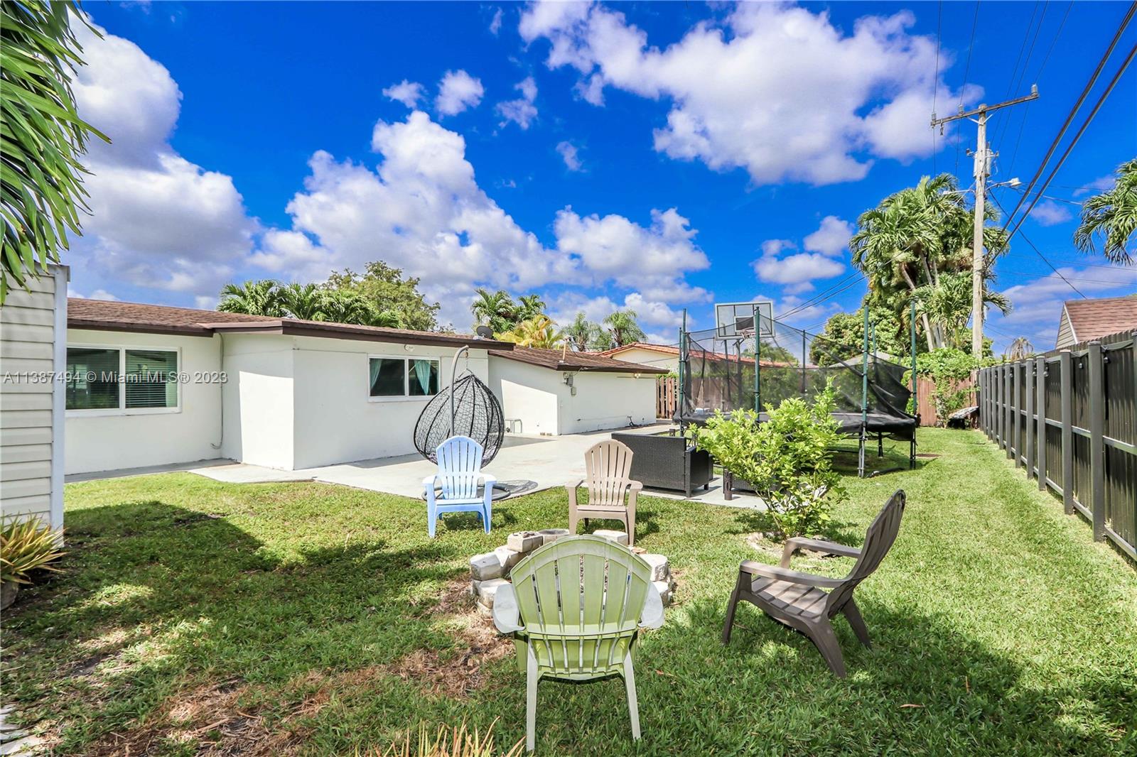 9275 Southwest 45th Street Miami, FL 33165 - Photo 2 of 23 a backyard of a house with table and chairs plants and large tree