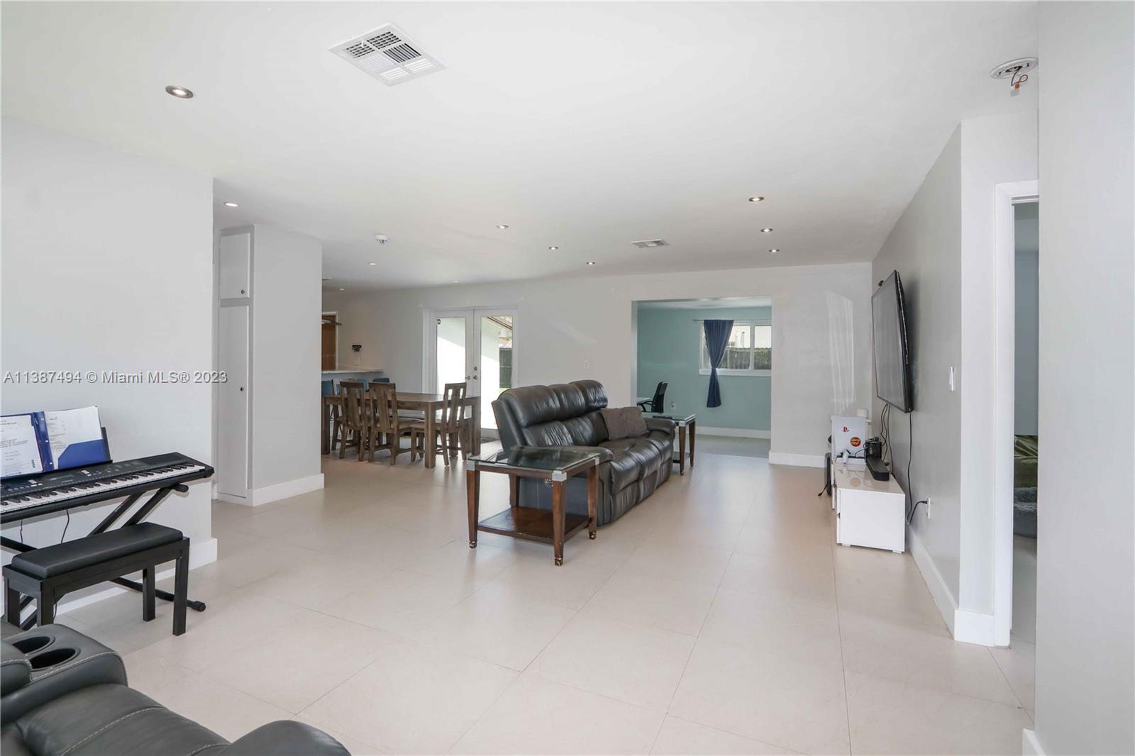 9275 Southwest 45th Street Miami, FL 33165 - Photo 7 of 23 a living room with furniture and a chandelier