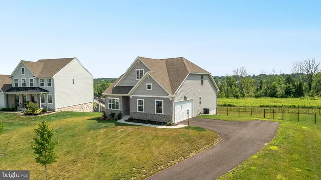 a front view of a house with yard and green space