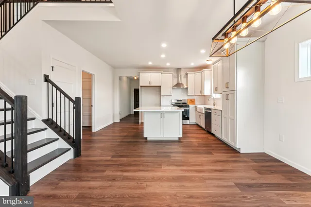 a view of a kitchen with wooden floor and electronic appliances