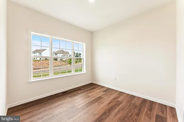 an empty room with wooden floor and a window